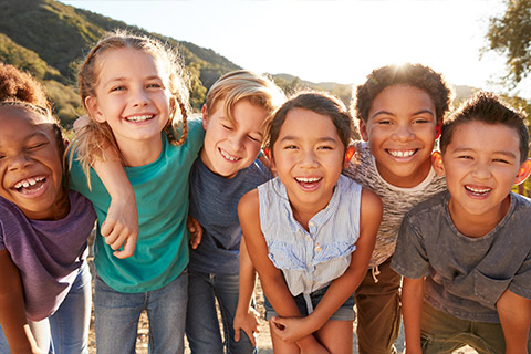 A group of children smiling in a park