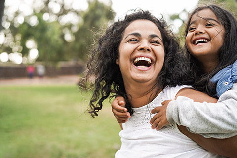 A woman and her daughter playing in the park